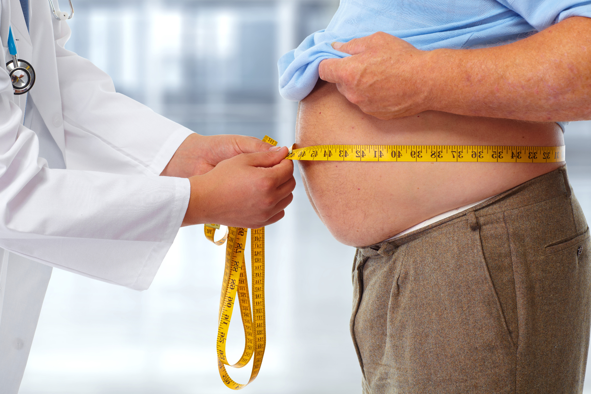 Doctor measuring a patient's waist — obesity is a common VA denial reason for sleep apnea