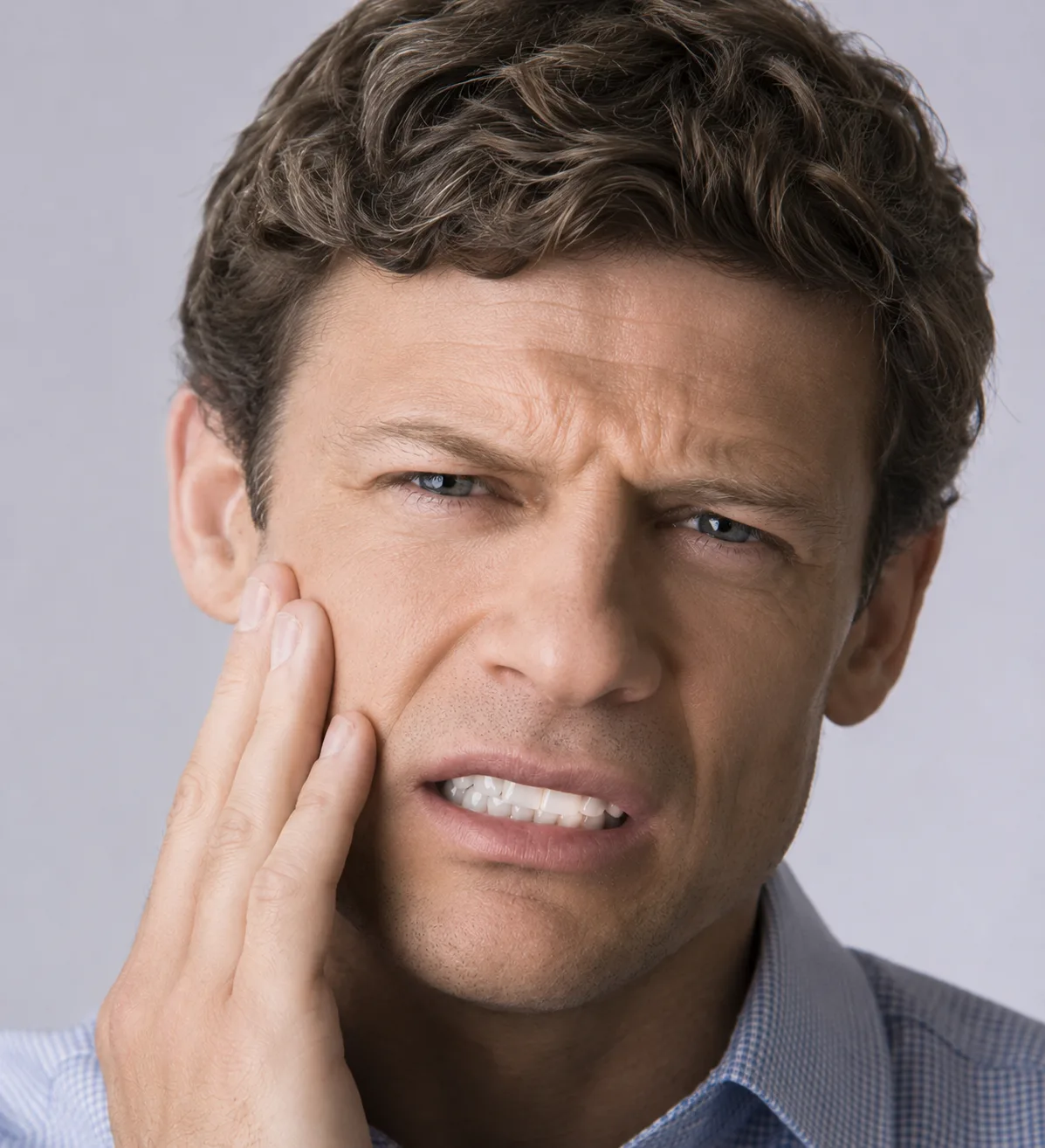 Veteran holding his jaw in pain from TMJ dysfunction